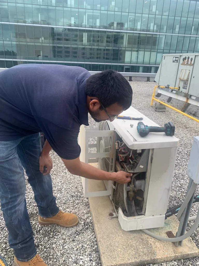 Uncovering Hidden Fees: What to Expect When Hiring an HVAC Contractor in Fairfax 1 Technician inspecting an air conditioning unit on a rooftop.